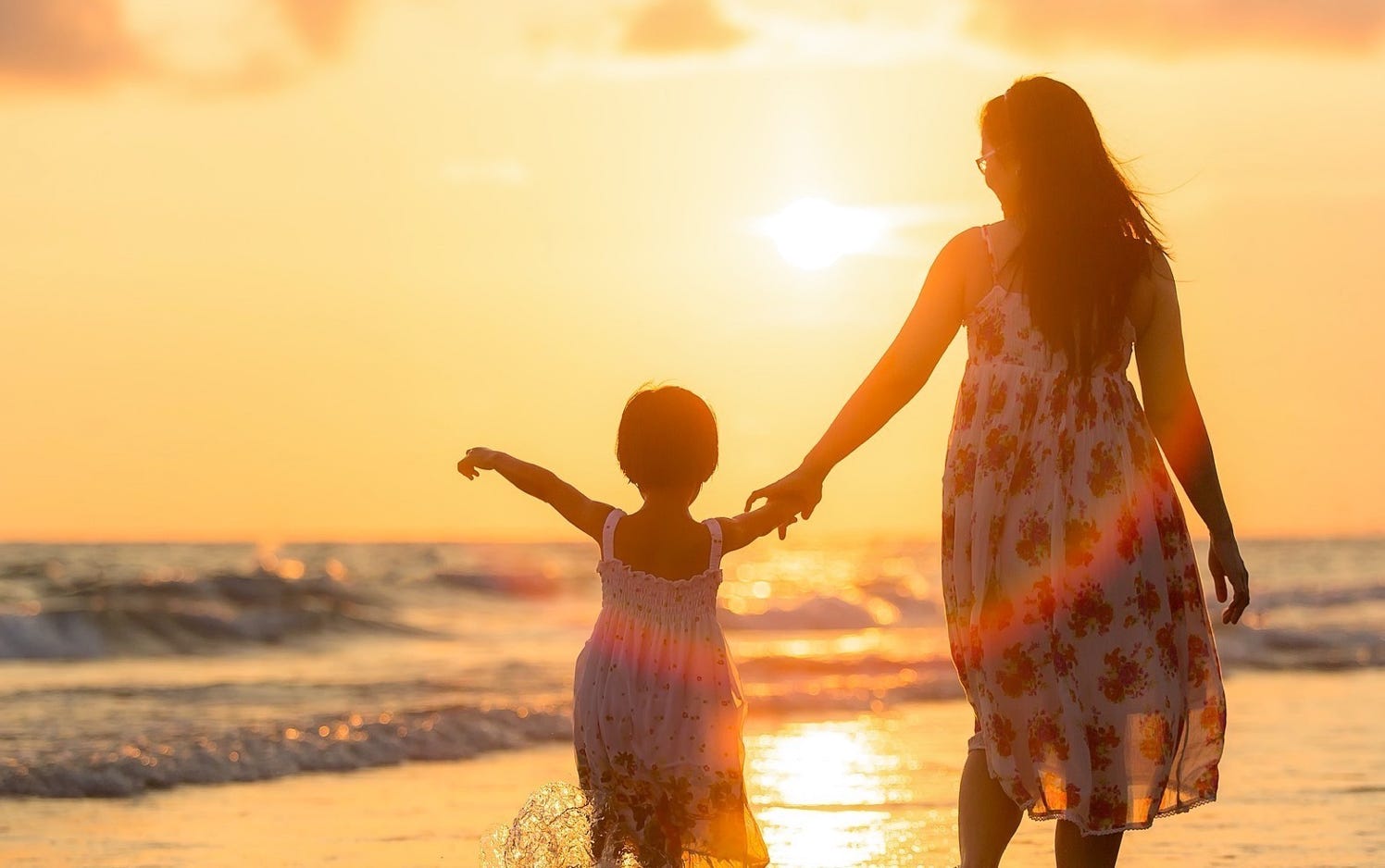Mom walking with daughter on beach
